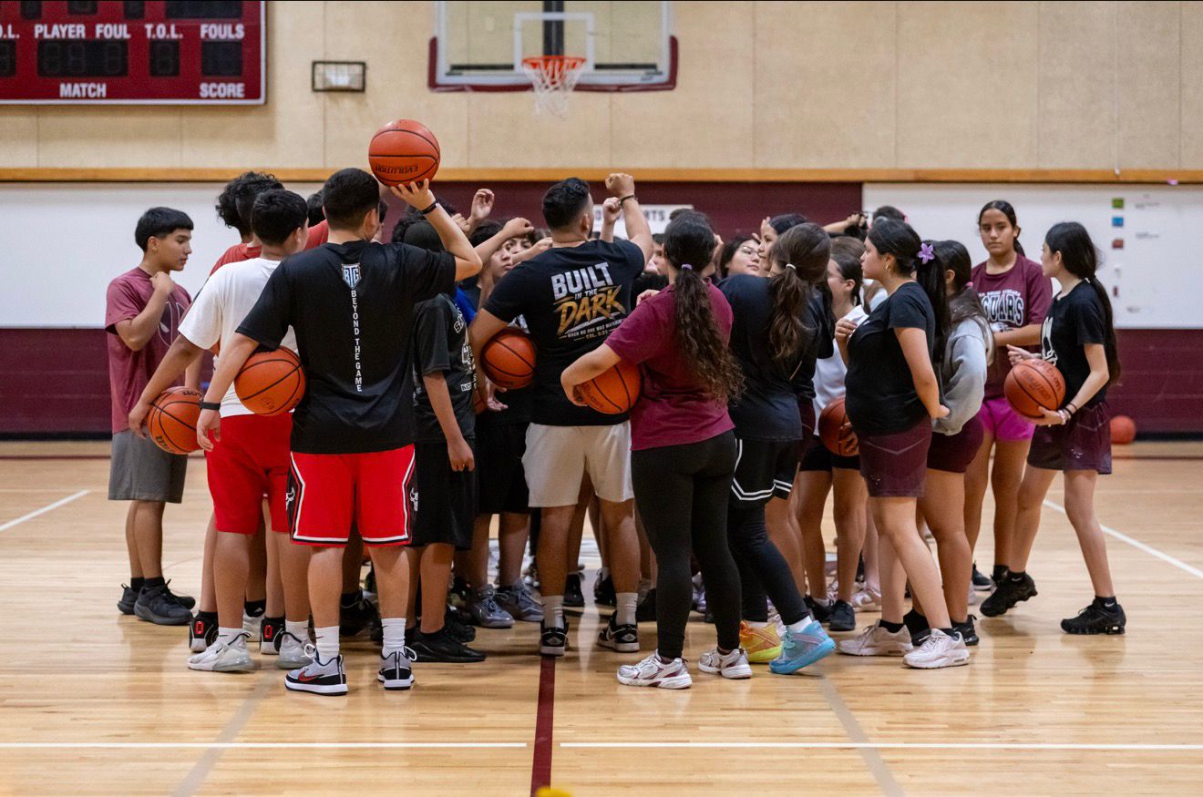 Daniel Rosas in a team huddle with basketball players