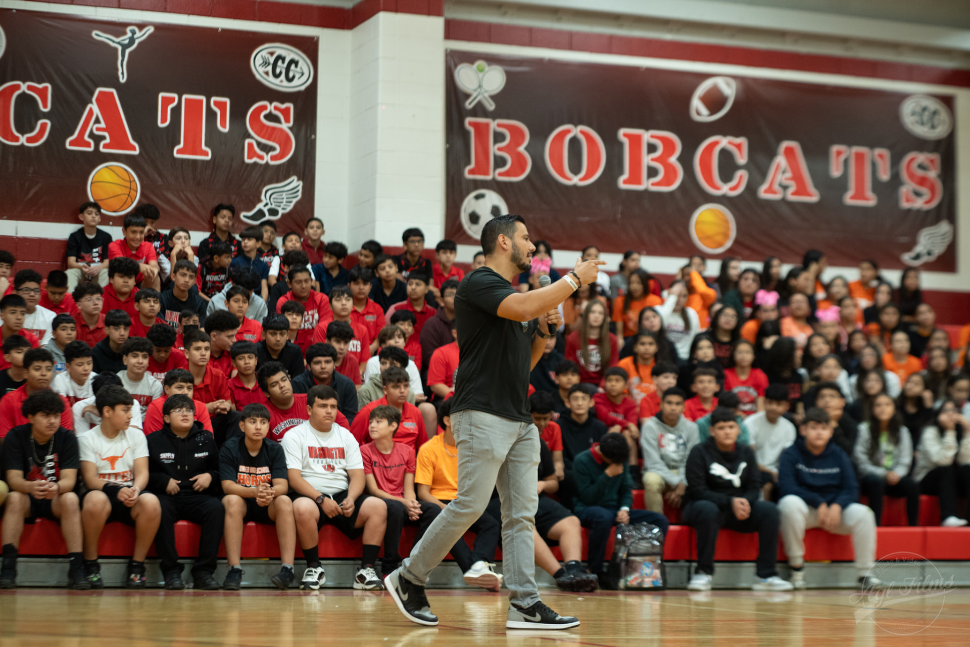 Daniel Rosas speaking to a full gym of students at a school assembly
