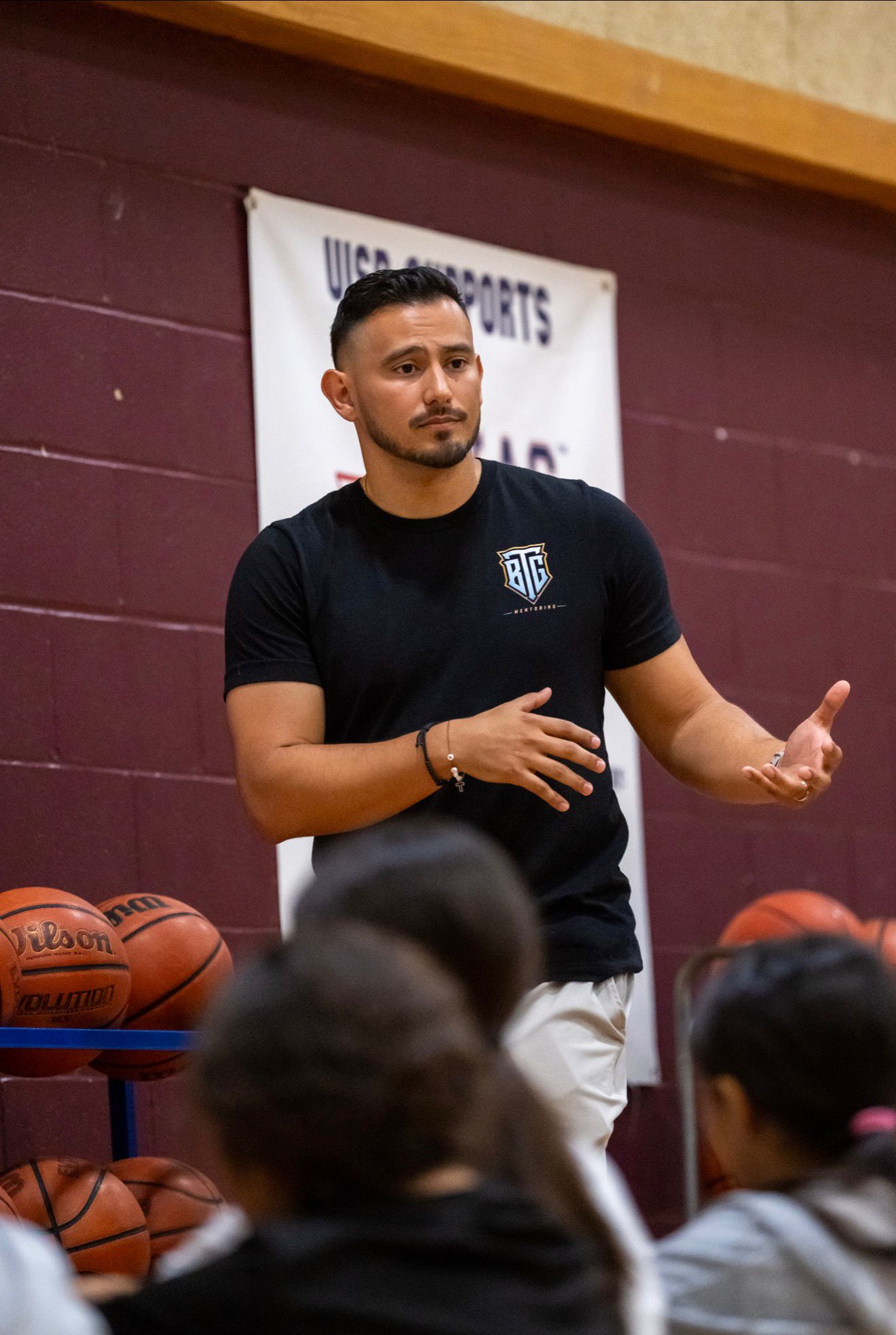 Portrait of Daniel Rosas speaking to athletes