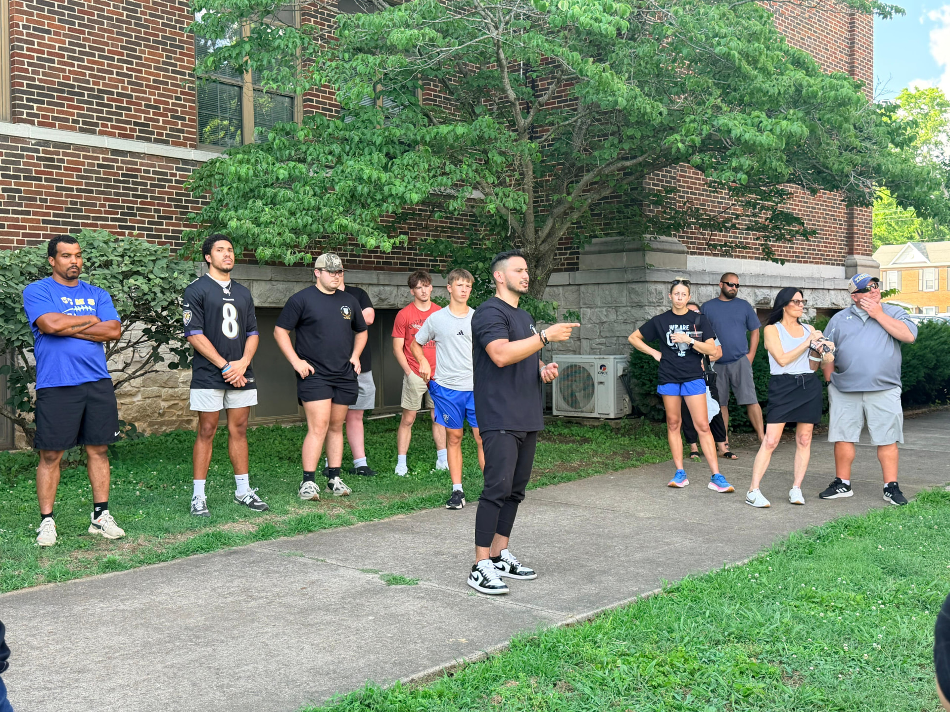 Daniel Rosas leading a group of coaches and athletes outdoors
